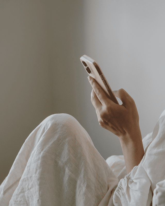 Lady looking at her phone - at Bee Natural Cleaning's Reviews